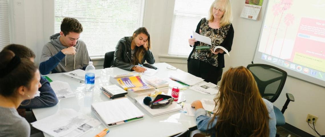 Sprachlehrerin erklärt Aufgabe im Klassenraum 