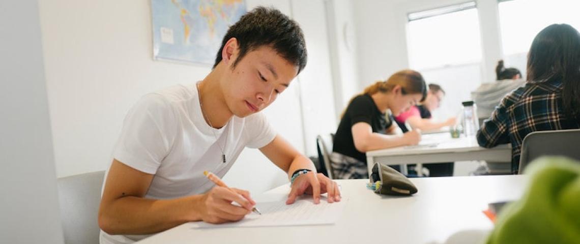 Sprachschüler löst im Klassenraum Aufgabe