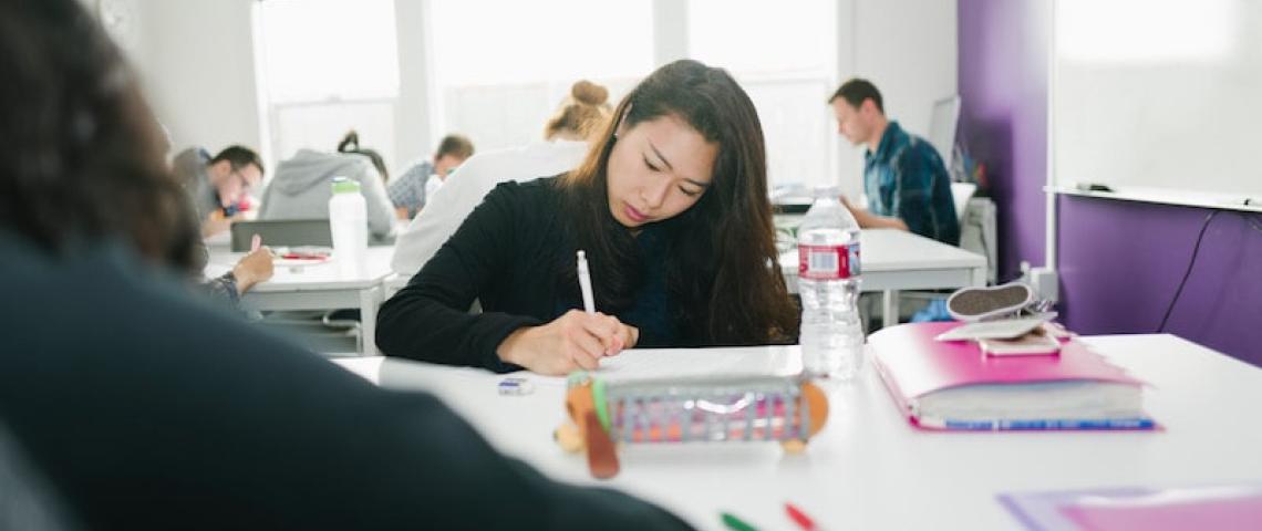 Sprachschülerin im Klassenzimmer löst Aufgabe