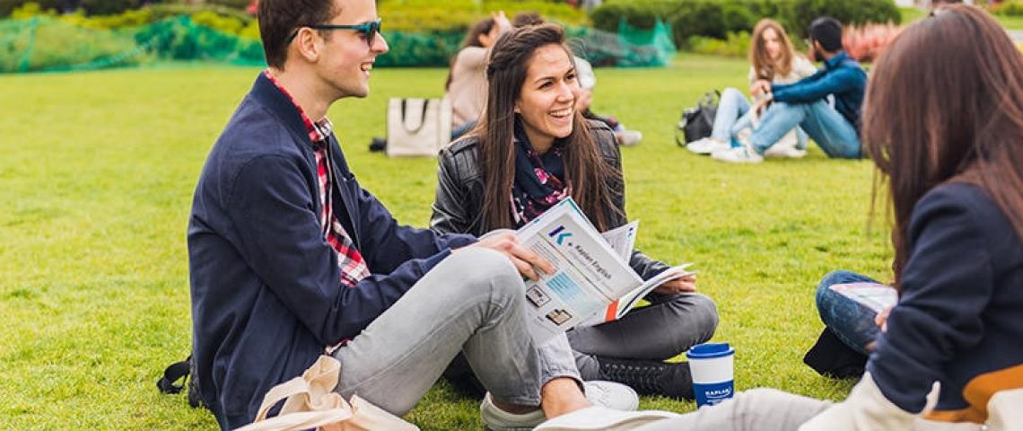 Sprachschüler sitzen auf Wiese Freizeit Sprachreise