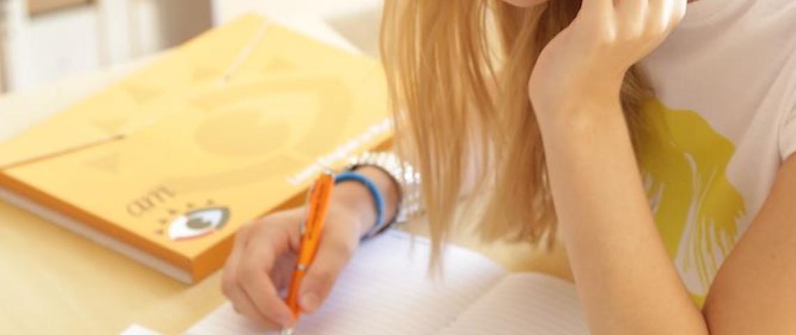 Junge Schülerin lernt am Tisch in Sliema