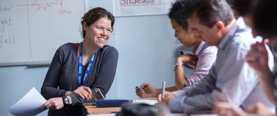 Lehrerin der Sprachschule erklärt den Sprachschülern den Lernstoff